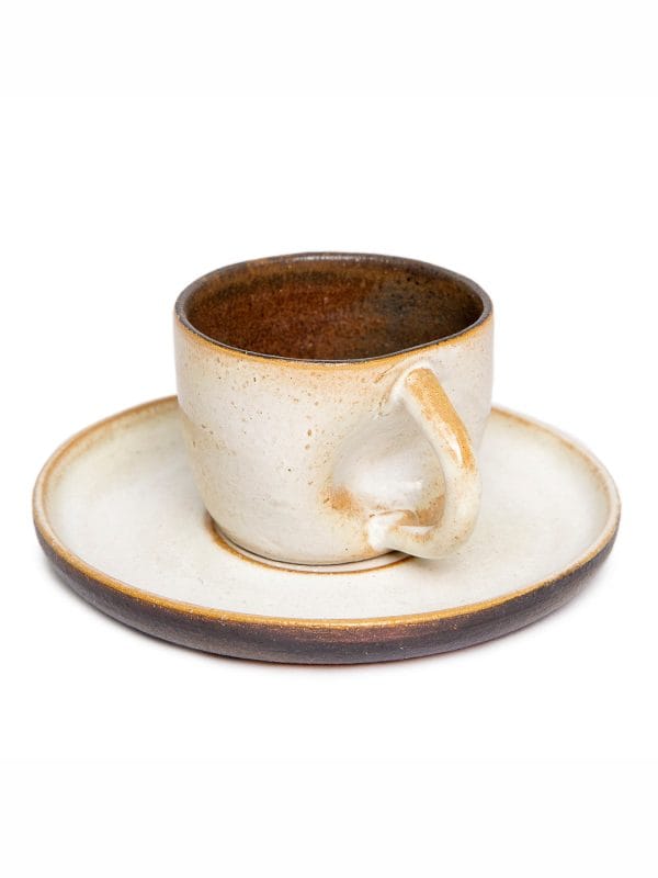 A xícara de café contemporânea sem alça na cor off é a verdadeira cara da marca Danielle Raiola. Apesar de delicada, ela possui um design marcante com detalhe amassado perto da área de manuseio, imprimindo muita personalidade à sua mesa posta.