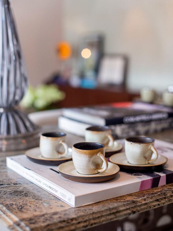 A xícara de café contemporânea sem alça na cor off é a verdadeira cara da marca Danielle Raiola. Apesar de delicada, ela possui um design marcante com detalhe amassado perto da área de manuseio, imprimindo muita personalidade à sua mesa posta.