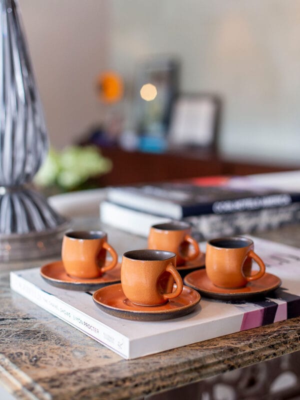 A xícara de café contemporânea sem alça na cor terracota é a verdadeira cara da marca Danielle Raiola. Apesar de delicada, ela possui um design marcante com detalhe amassado perto da área de manuseio, imprimindo muita personalidade à sua mesa posta.