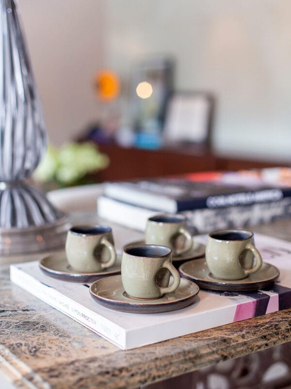 A xícara de café contemporânea sem alça na cor oliva é a verdadeira cara da marca Danielle Raiola. Apesar de delicada, ela possui um design marcante com detalhe amassado perto da área de manuseio, imprimindo muita personalidade à sua mesa posta.